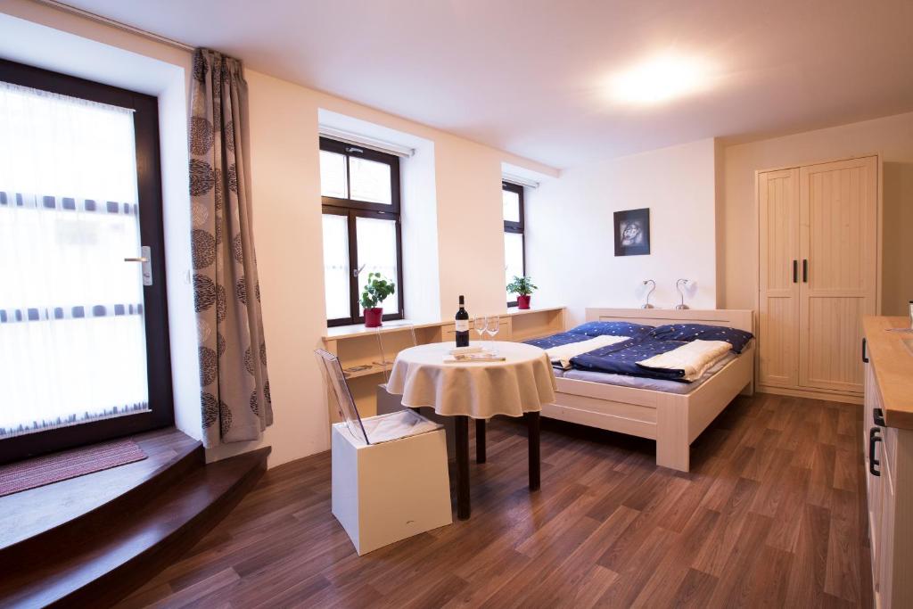 a bedroom with a bed and a table and a window at Apartment historical city in Znojmo