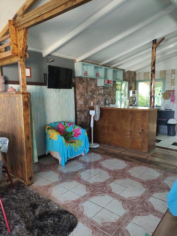 a living room with a couch in the middle of a room at Cabañas Kitai in Hanga Roa