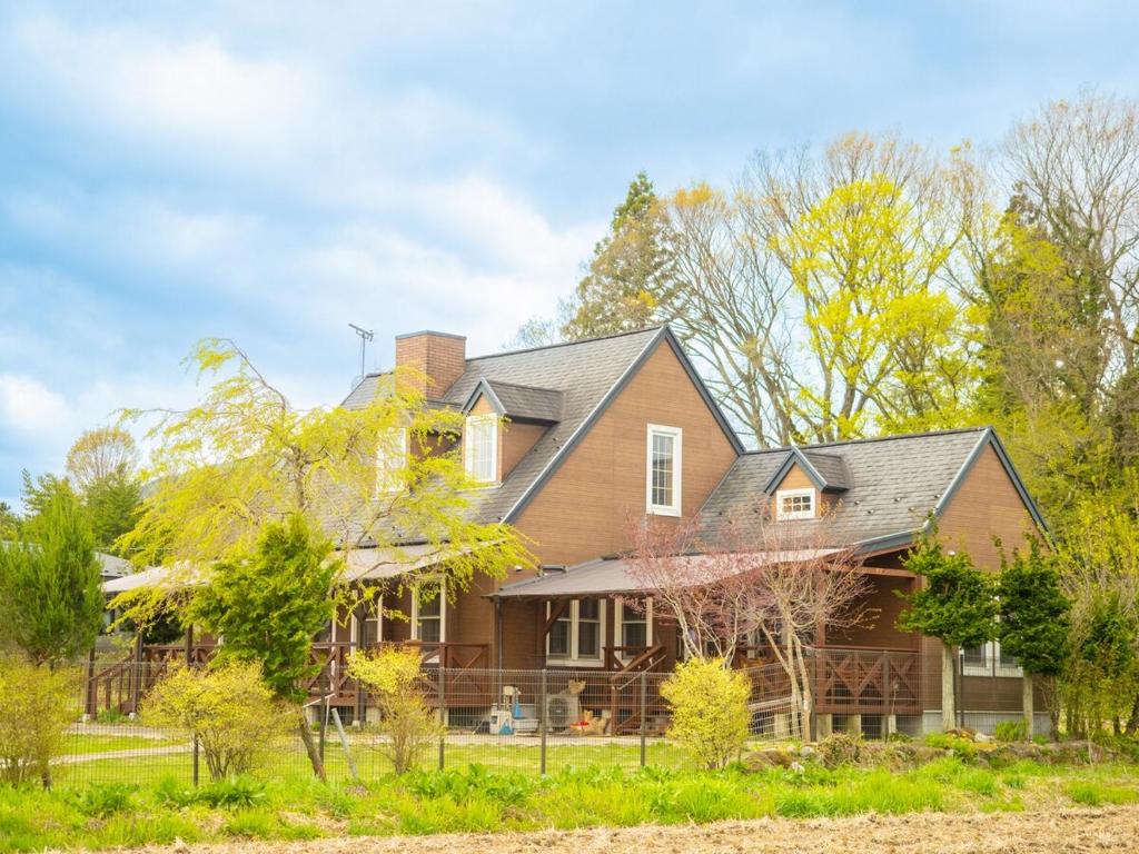 a house in the woods with trees at Elle's Garden House 高いフェンスに囲まれた広い庭でペットは大満足 雨の日もBBQ可能 in Nasushiobara