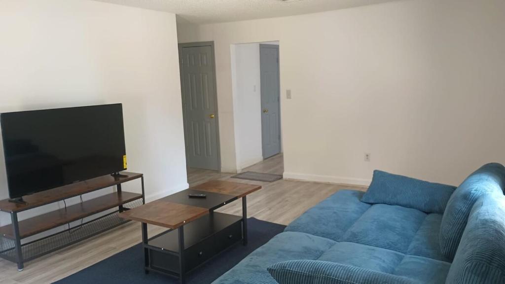 a living room with a blue couch and a tv at House in Malvern, AR in Malvern