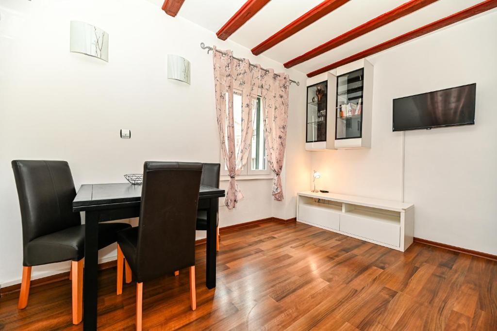 een eetkamer met een tafel en een televisie bij Apartment Aldora in Zadar