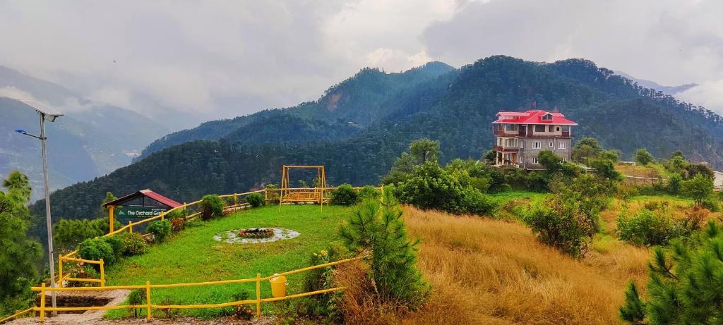 a house on a hill with mountains in the background at Orchard Green Dummi in Nāldera