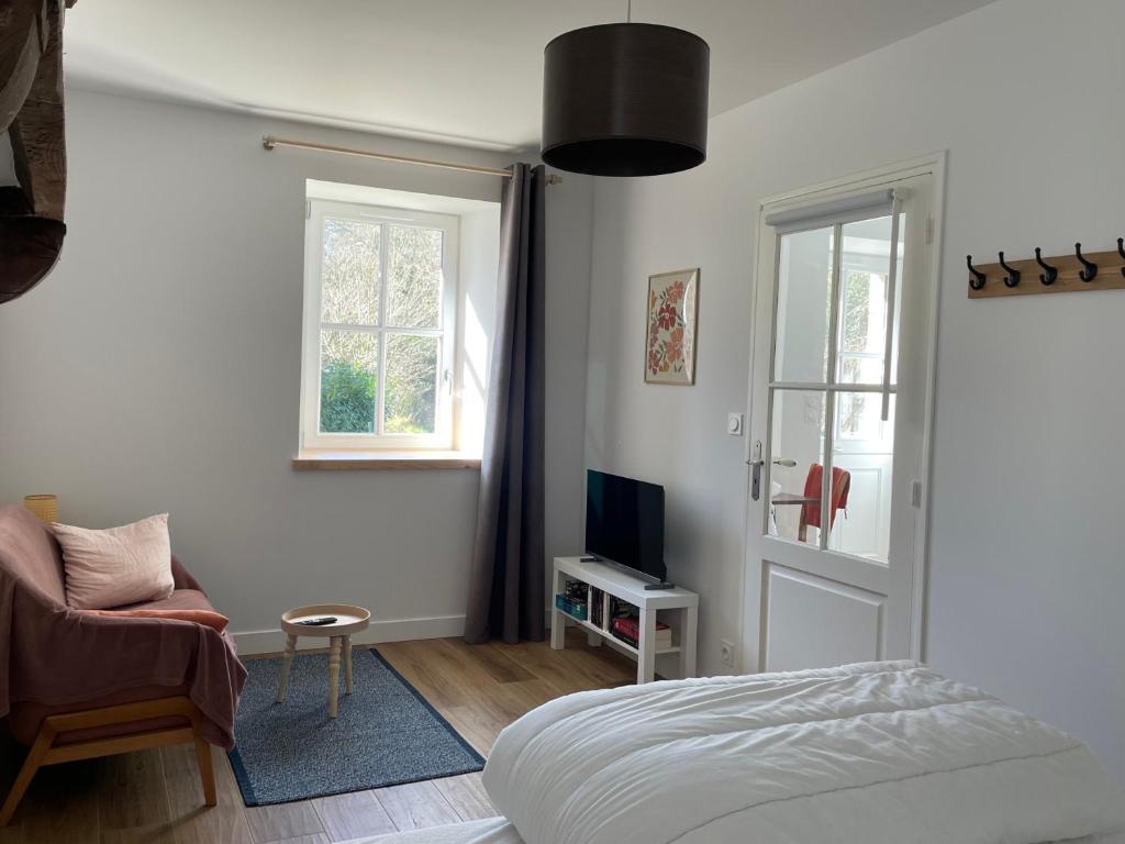 une chambre avec un lit, une chaise et une fenêtre dans l'établissement Petit gîte - Ty Bihan, à Querrien