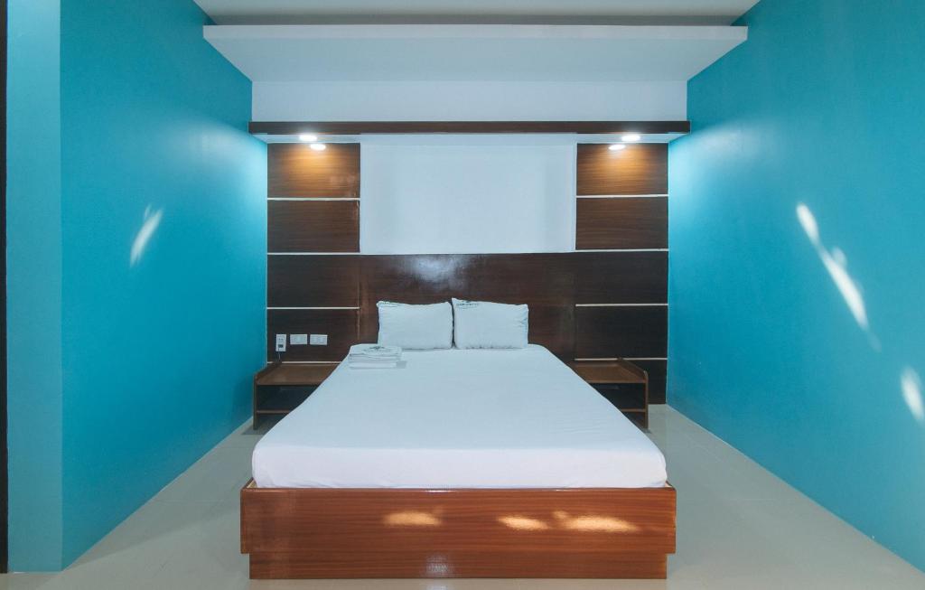 a bedroom with a bed with a blue wall at Ranchotel General Trias Cavite by RedDoorz in Uldugan