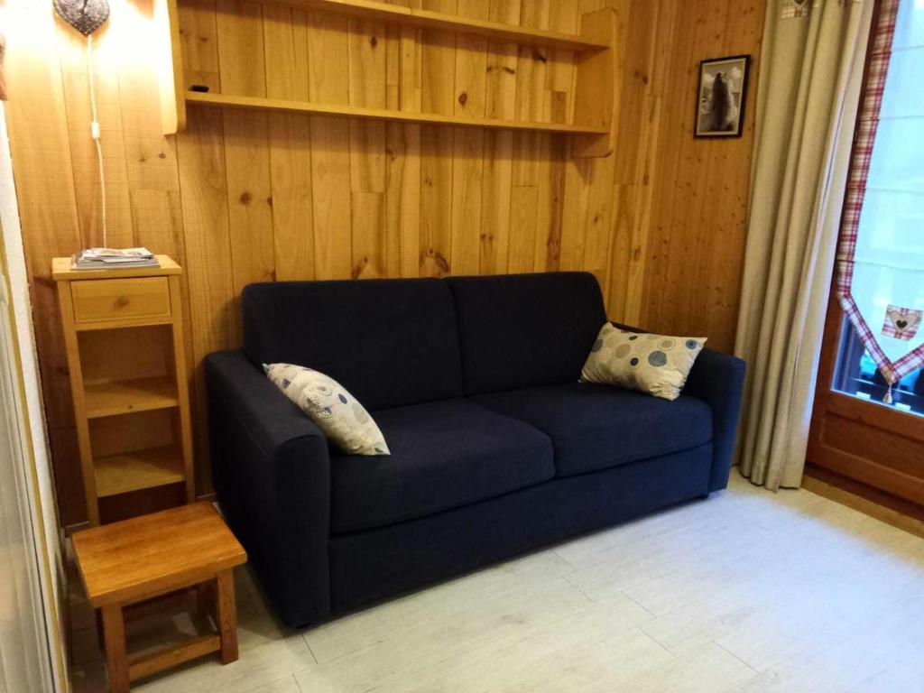 - un canapé bleu dans une chambre dotée d'un mur en bois dans l'établissement Résidence La Croix Du Sud - Studio cabine 4 personnes 2 exposé nord MAE-7924, à Valloire