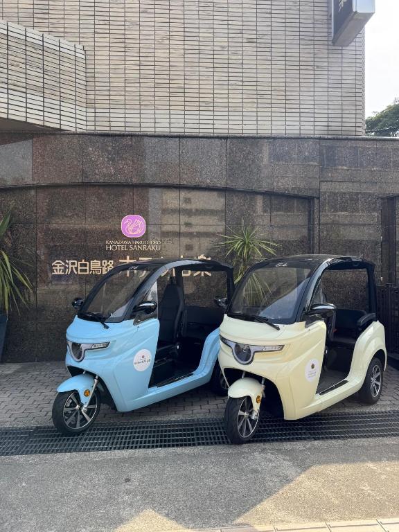 two electric cars parked in front of a building at Kanazawa Hakuchoro Hotel Sanraku -Natural Hot Spring- in Kanazawa