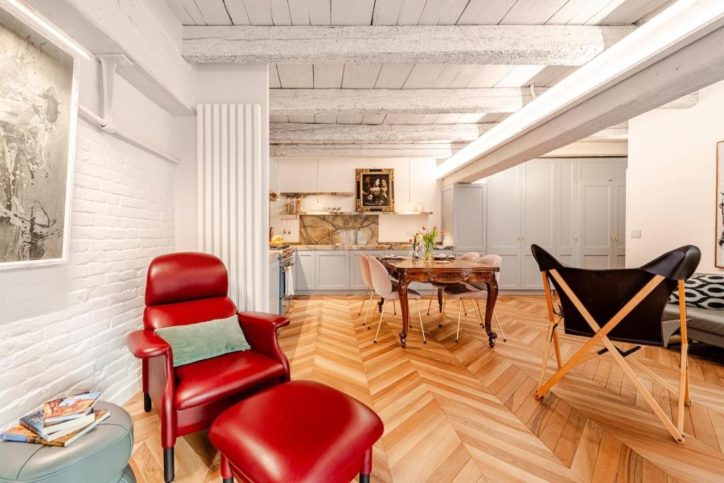 博洛尼亚Deluxe Suite Fine Art Historic Centre的带红色椅子和桌子的客厅