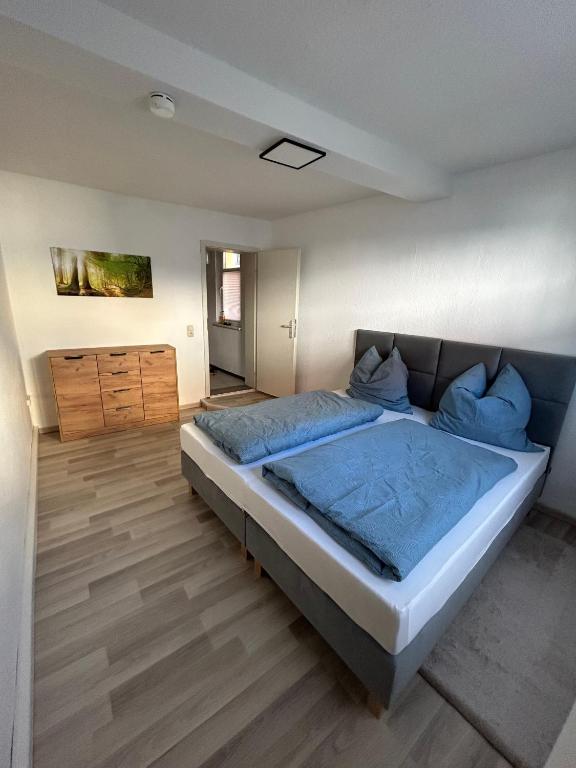 a bedroom with a large bed with blue sheets at Schönes 4-Zimmer Appartment, WLAN, Küche, BAD in Ilmenau