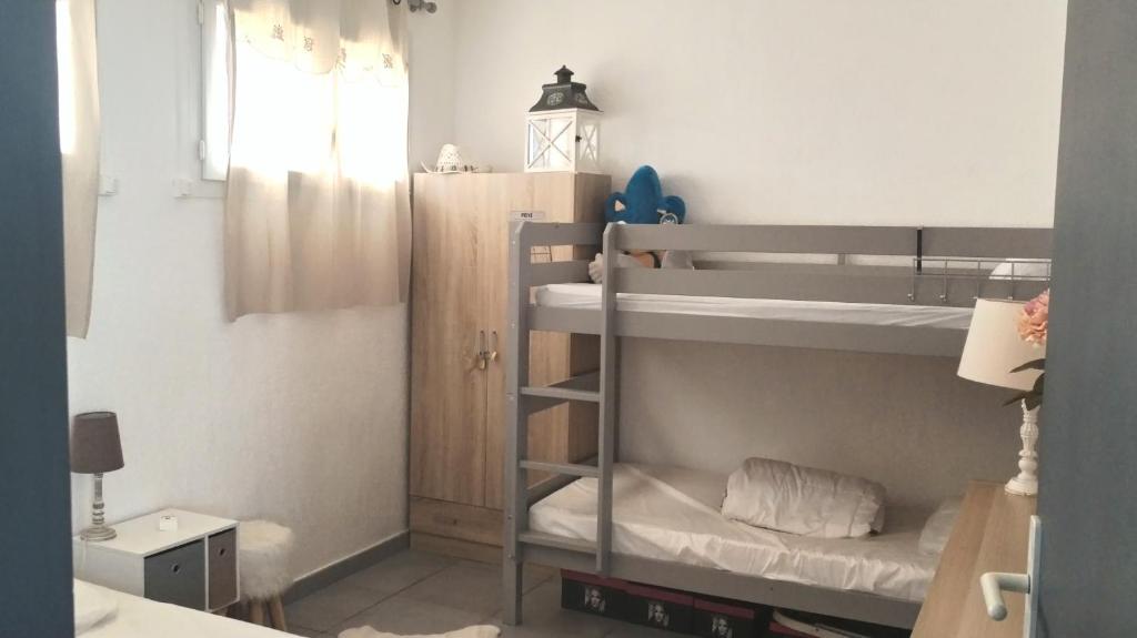 une chambre avec deux lits superposés et une fenêtre dans l'établissement Appartement front de mer, à Saint Cyprien Plage