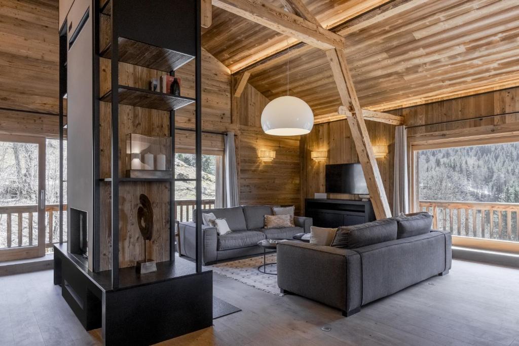 un salon avec deux canapés et une cheminée dans l'établissement Ferme des Tétras - Chalet de prestige en montagne, à Saint-Gervais-les-Bains