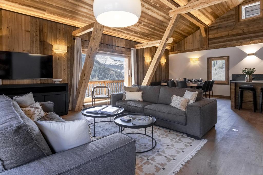 a living room with two couches and a table at Ferme des Tétras - Chalet de prestige en montagne in Saint-Gervais-les-Bains