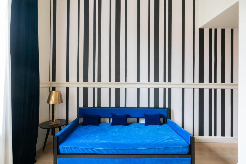 a blue bed in a room with a striped wall at Roma Luxus Hotel in Rome