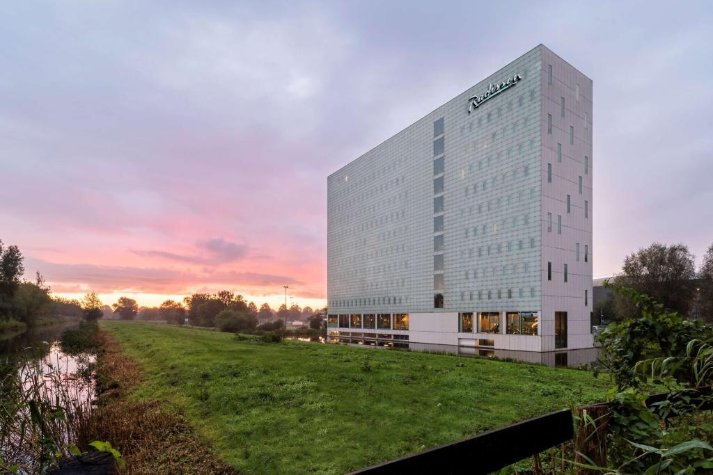 a rendering of a building with a field in front at Radisson Hotel & Suites Amsterdam South in Amstelveen