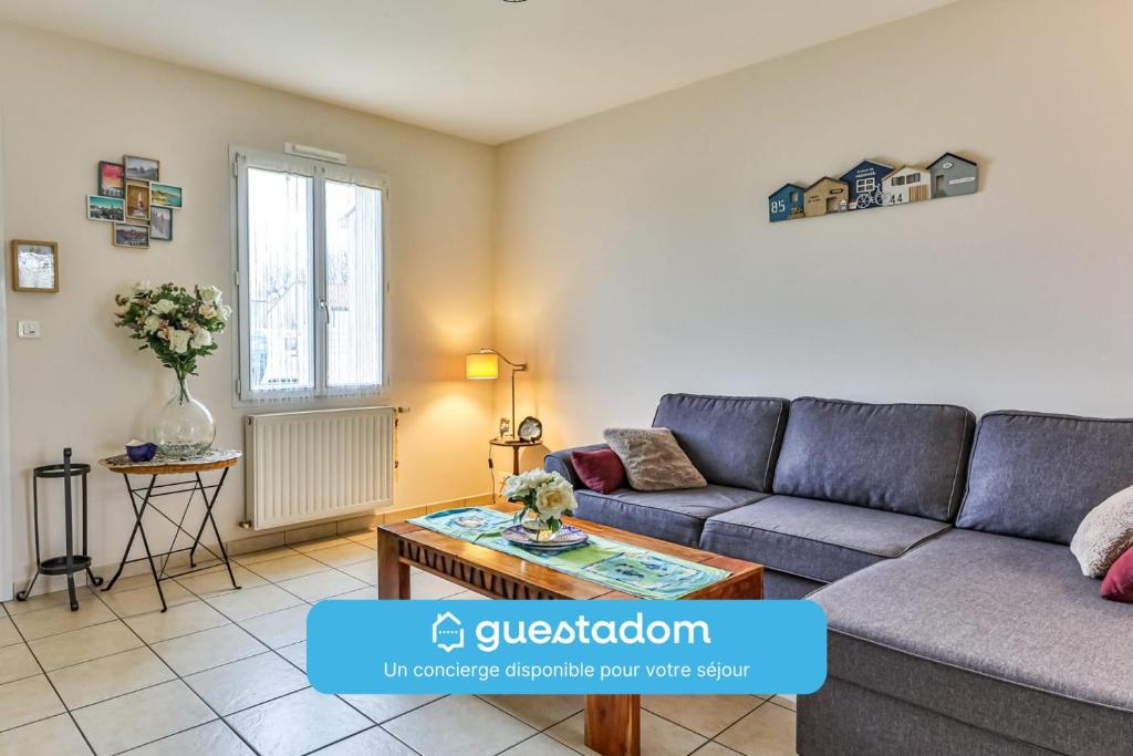 a living room with a couch and a table at Les Pinsons - Jardin - Parking - Wifi in Challans