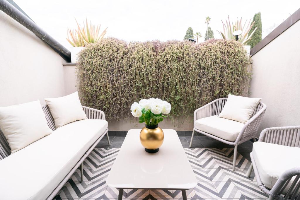 a vase of flowers sitting on a table on a patio at Roma Luxus Hotel in Rome