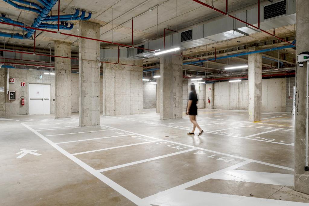 a person walking through an empty parking lot at aparto Milan Ripamonti in Milan