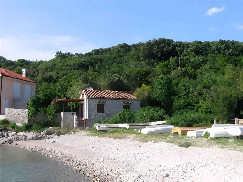 a house on the beach with boats on the shore at Holiday home in Stivan - Insel Cres 13654 in Štivan