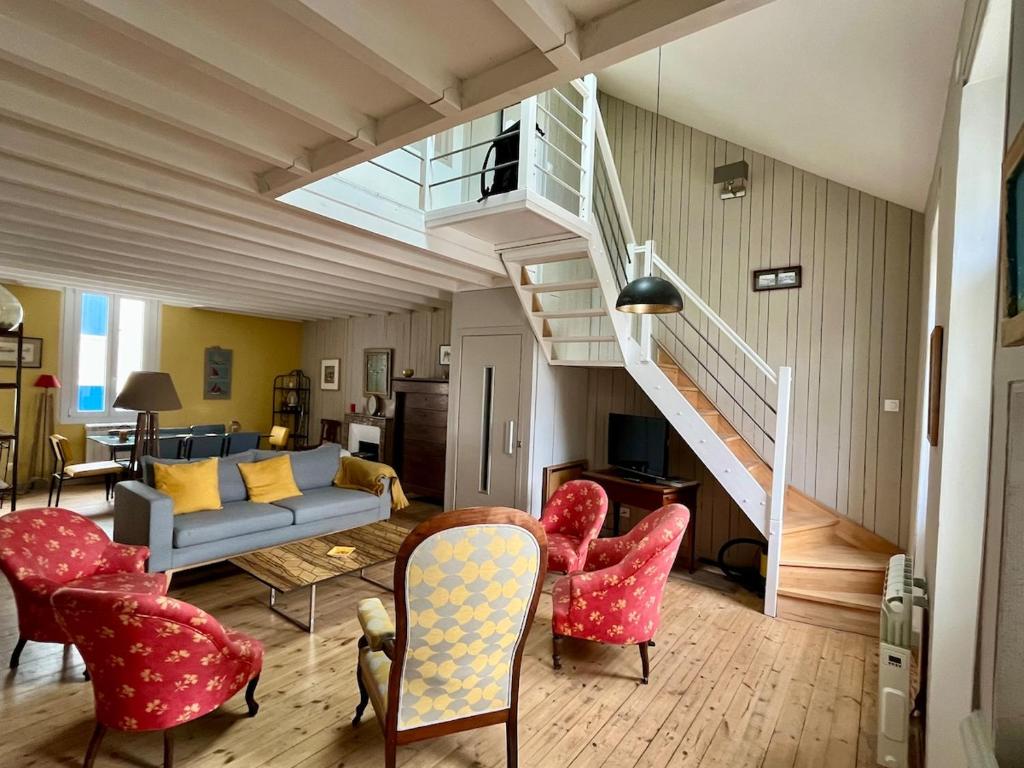 - un salon avec un canapé, des chaises et un escalier dans l'établissement Villa St Gilles - Quartier ARAGO - 300m Plage, à Les Sables-dʼOlonne