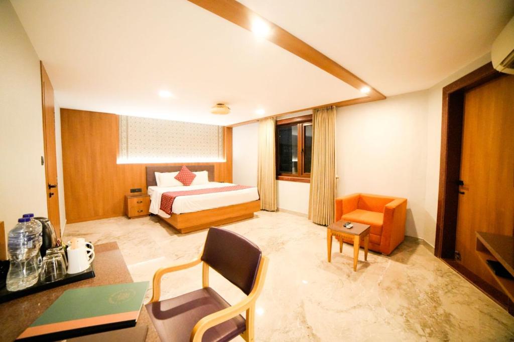 a hotel room with a bed and a table and chairs at Hotel Surya, Kaiser Palace in Varanasi