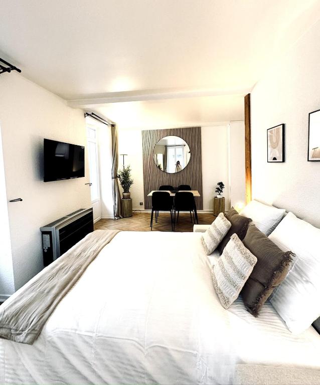 une chambre avec un grand lit blanc et une table dans l'établissement Studio neuf climatisé - Triangle d'Or, à Vichy