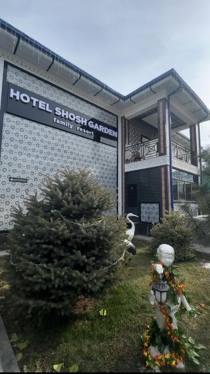 a hotelitz garden with a christmas tree in front of a building at Shosh Garden Family Resort in Chorwoq