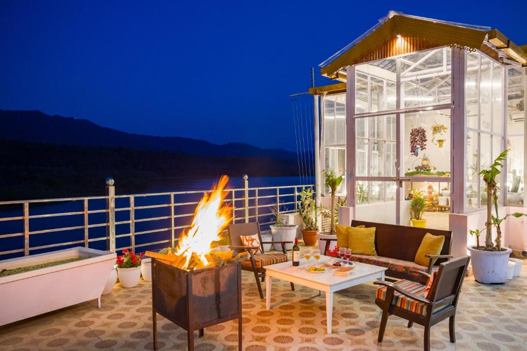 sala de estar con chimenea en el patio en ELIVAAS BYDM The Ganges 2 BHK Glasshouse Villa With Pvt Pool & Lift, en Rishīkesh
