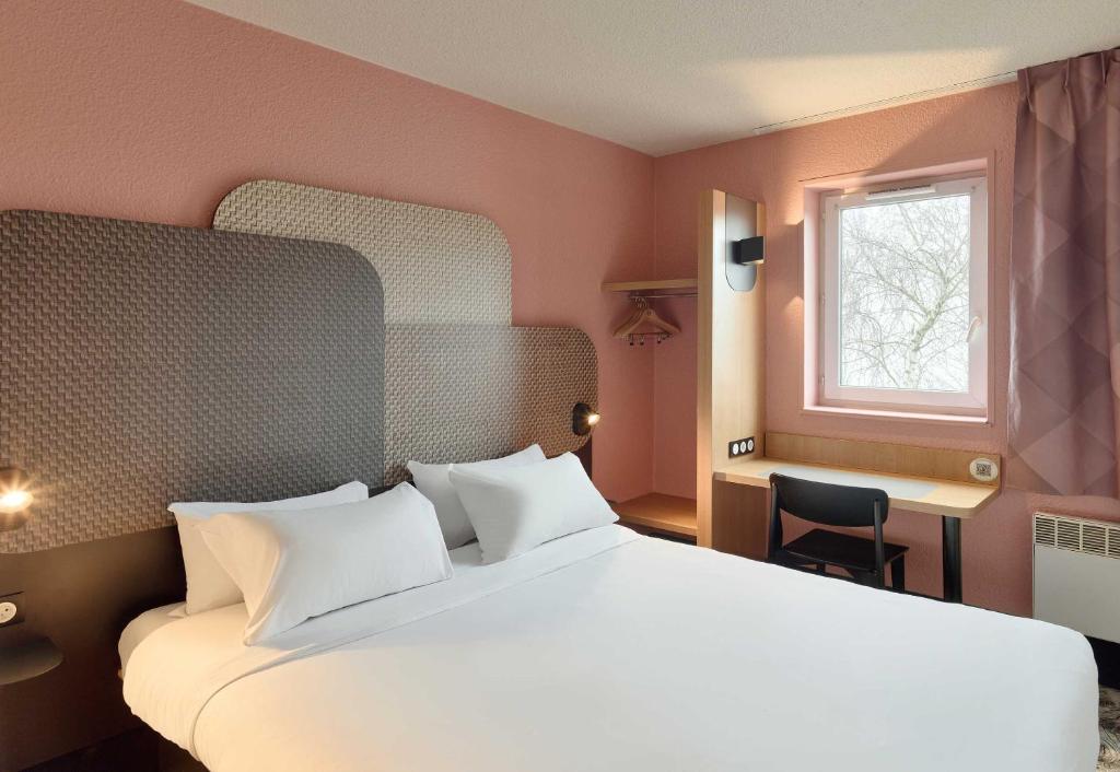 a bedroom with a large white bed and a window at B&B HOTEL Noisy-le-Grand in Noisy-le-Grand