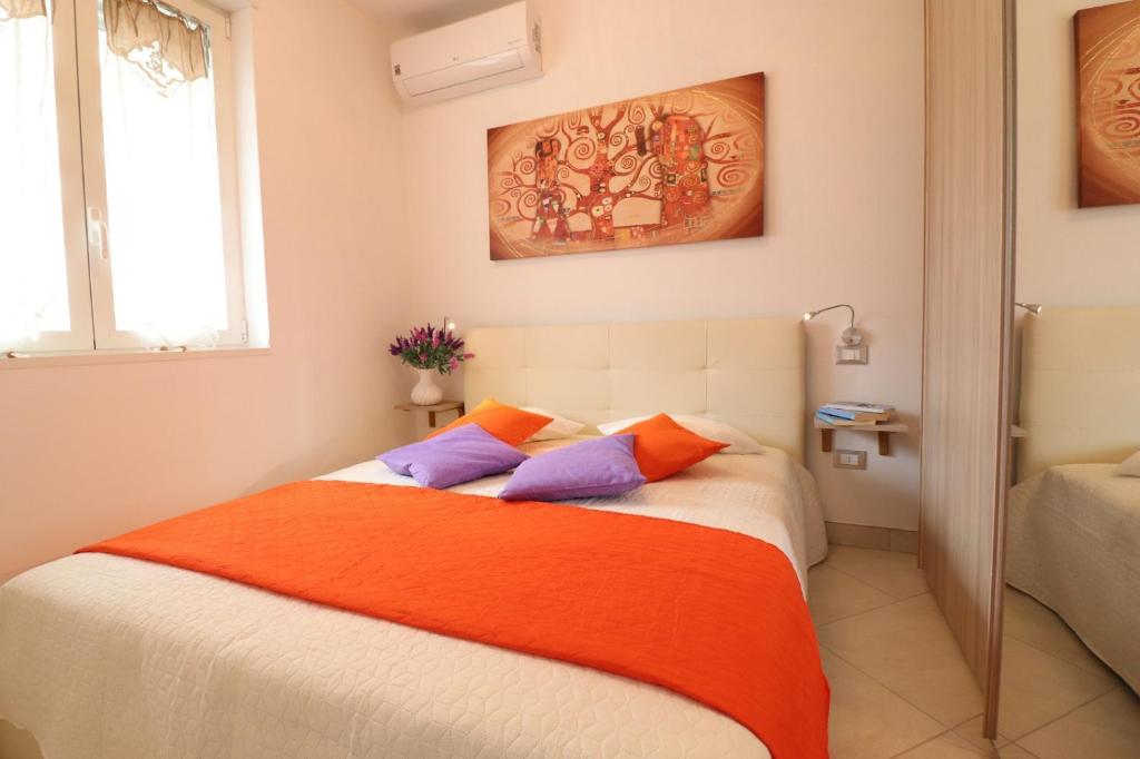 a bedroom with a bed with orange and purple pillows at Casa Francesca Otranto Modern 3 Guest Flat with AC & WiFi in Otranto