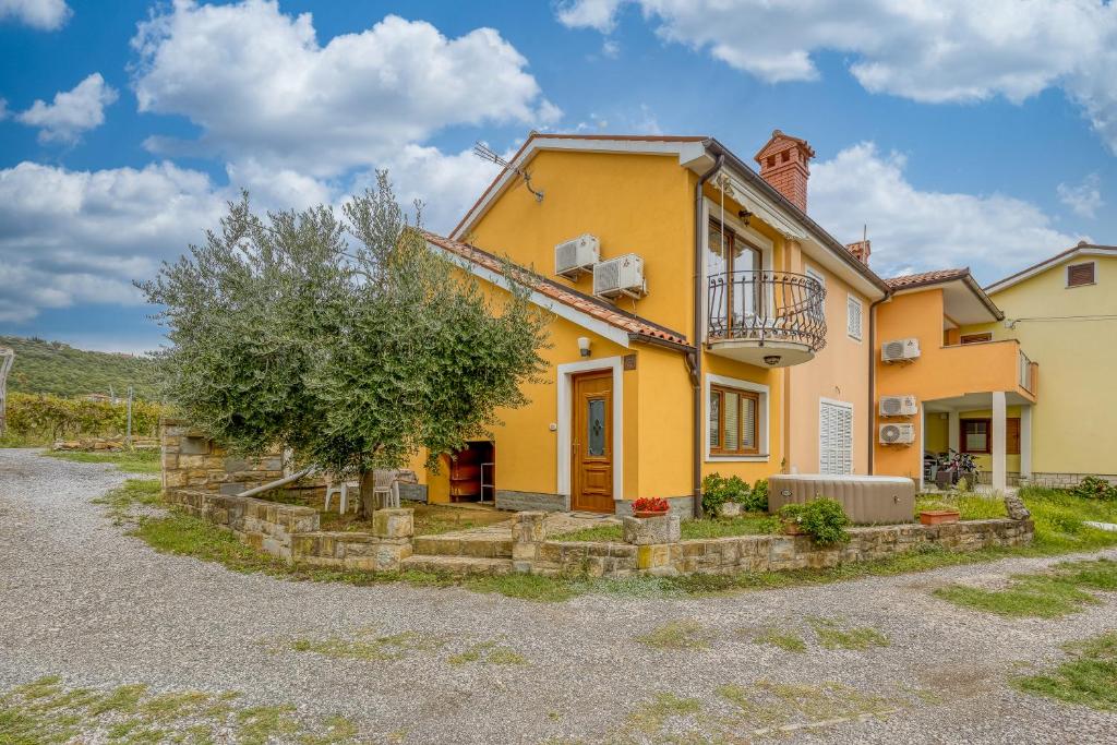 a yellow house with a tree in front of it at House In The Vineyard - Happy Rentals in Ankaran