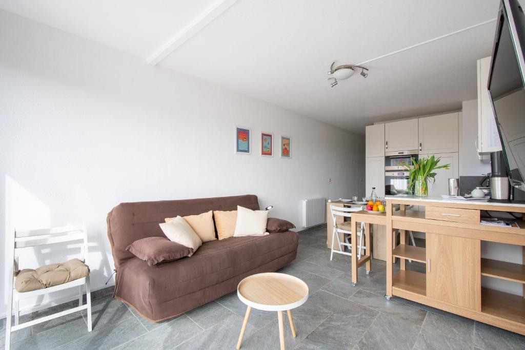 un salon avec un canapé et une cuisine dans l'établissement Escale au Boucanet - A 150m de la plage, au Grau-du-Roi