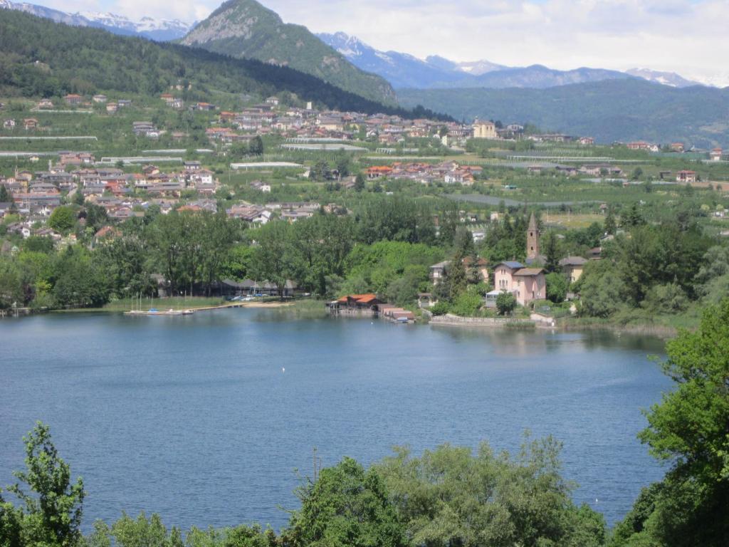 mit Blick auf einen See mit Stadt und Berge in der Unterkunft Residence Lago Blù in Pergine Valsugana