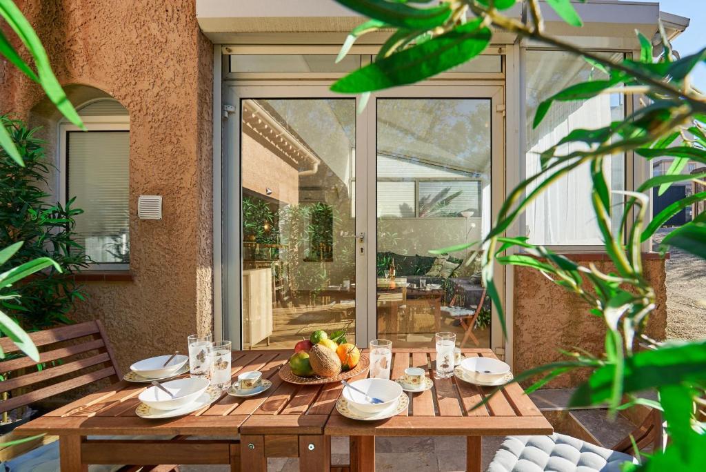 - une table en bois avec un bol de fruits dans l'établissement Escapade à Six-Fours - Plage, terrasse & parking, à Six-Fours-les-Plages