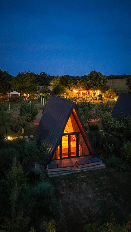 a small house with a lit up window at night at Perryland Urban Farm in Piatra