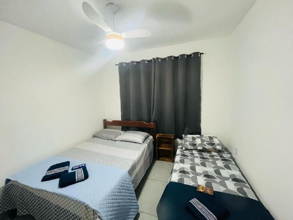 two twin beds in a room with a window at Casa com piscina Bauru SP in Bauru