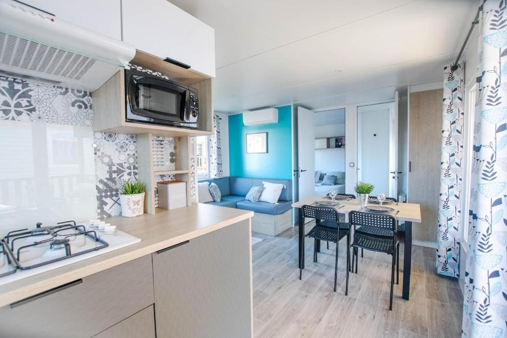 une cuisine et un salon avec une table et des chaises dans l'établissement Sekoya Lodge, Mobile Home 500m de la plage, à Seignosse