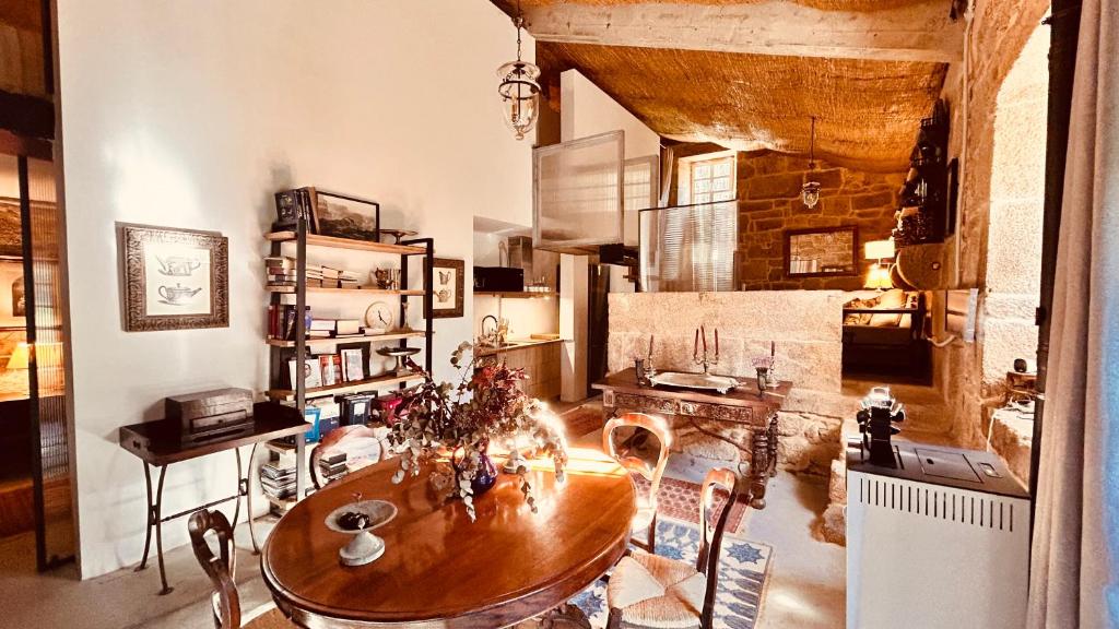 a dining room with a table and a kitchen at Los Lagares Manor House in Deán Pequeño