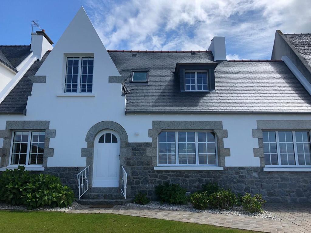 une maison blanche avec un toit gris dans l'établissement Gwaskedou, sea view, beach and city center, à Roscoff
