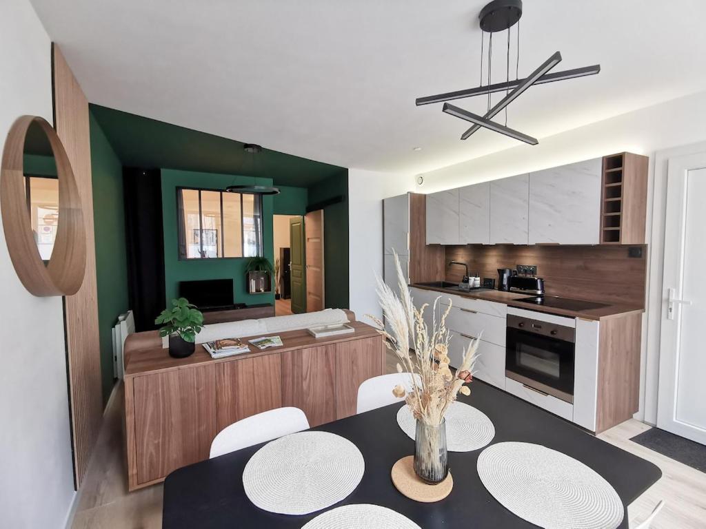 une cuisine et une salle à manger avec une table et des chaises dans l'établissement La Virgule, votre cocon dolois, à Dole