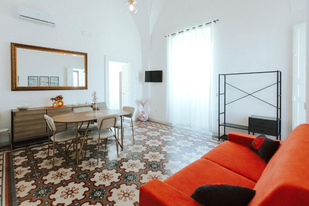 un soggiorno con un divano rosso e un tavolo di Casa Vacanze White Palace ad Alliste