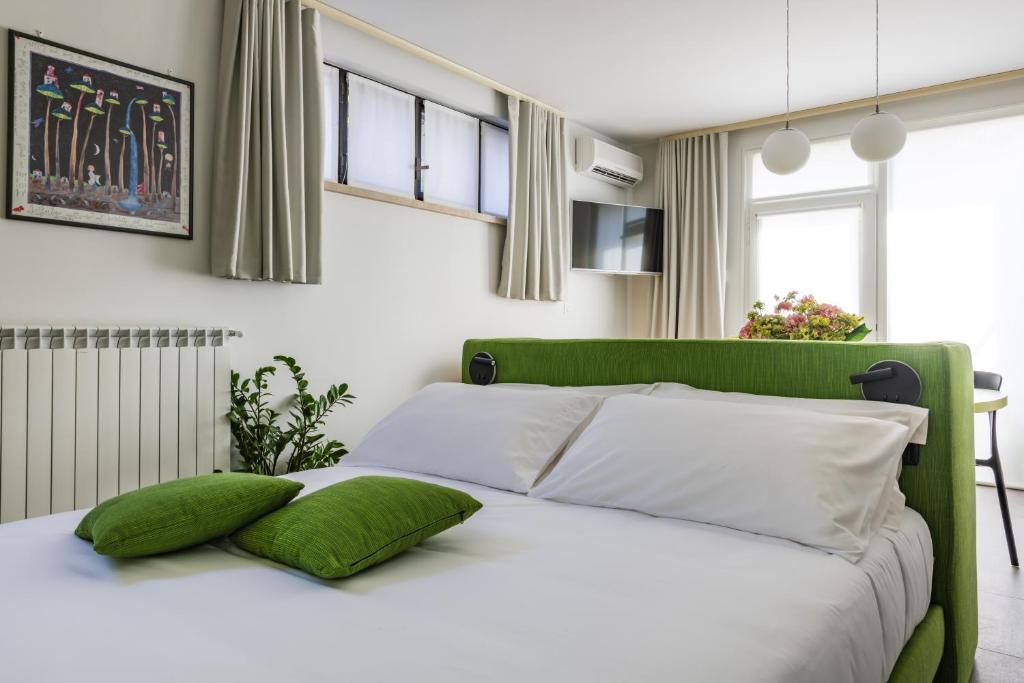 a green and white bed with two green pillows on it at Halloggio98 in Rivalta