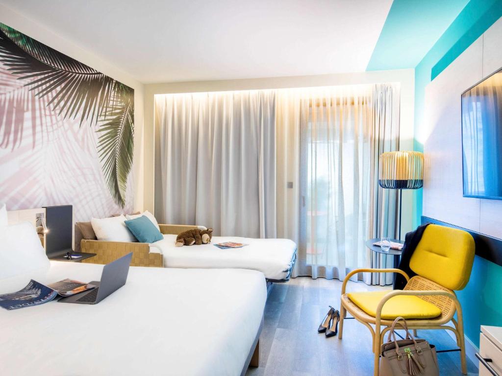 a hotel room with a bed and a couch at Novotel Monte-Carlo in Monte Carlo