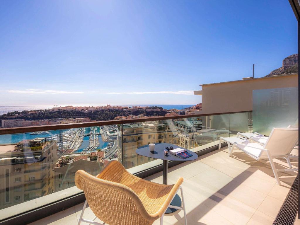 a balcony with chairs and a table on a building at Novotel Monte-Carlo in Monte Carlo