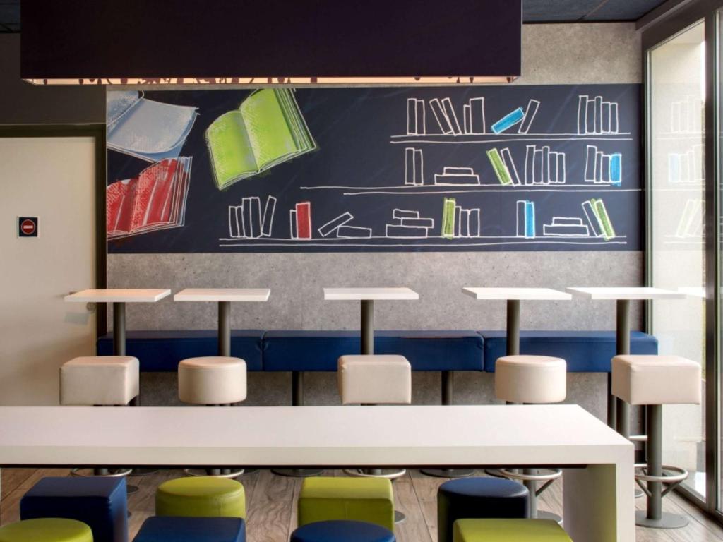 a classroom with tables and chairs and a chalkboard at ibis budget Montceau les Mines in Montceau-les-Mines