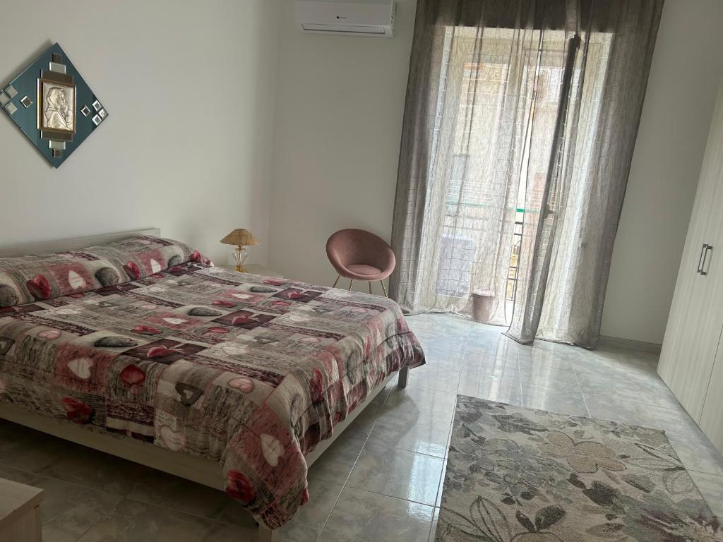 sypialnia z łóżkiem, krzesłem i oknem w obiekcie Casa vacanza da Paola w Trapani