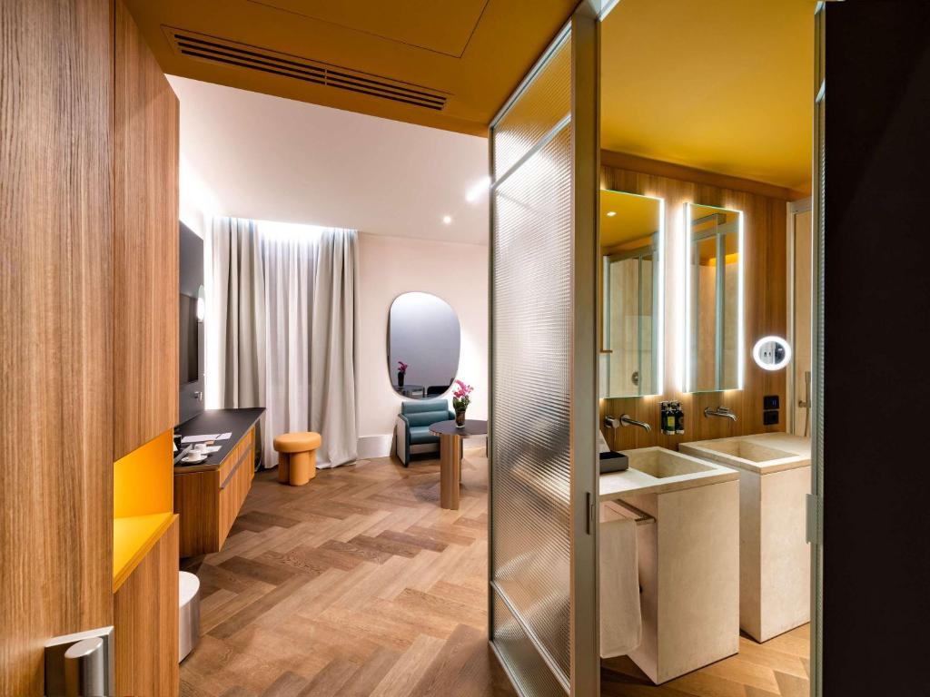 a bathroom with a sink and a mirror at Palazzo Tirso MGallery Cagliari in Cagliari