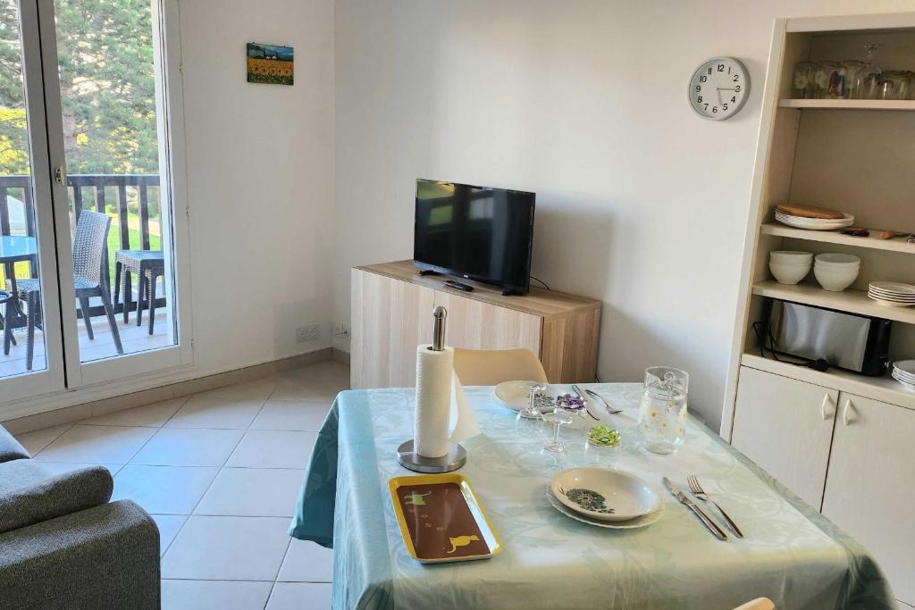 un salon avec une table et une télévision dans l'établissement Nice T2 with balcony - near beach, à Cabourg