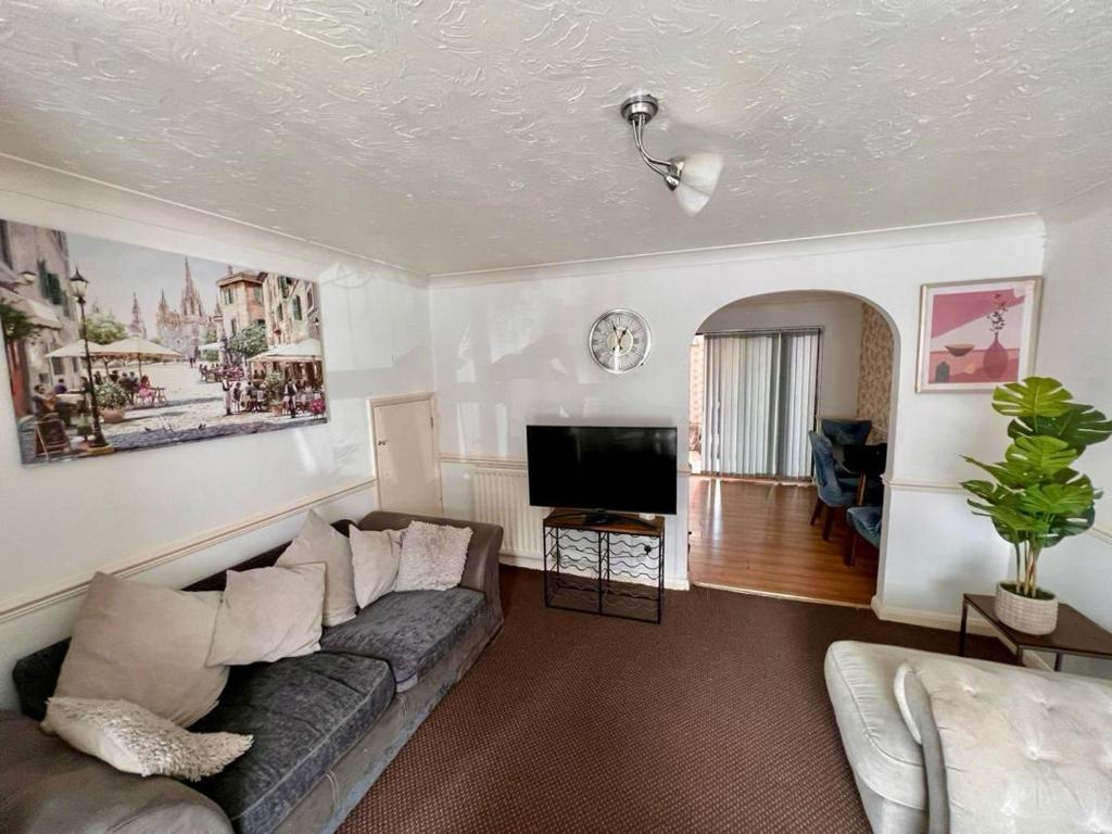 a living room with a couch and a flat screen tv at Bull Double bed in shared house in Stifford
