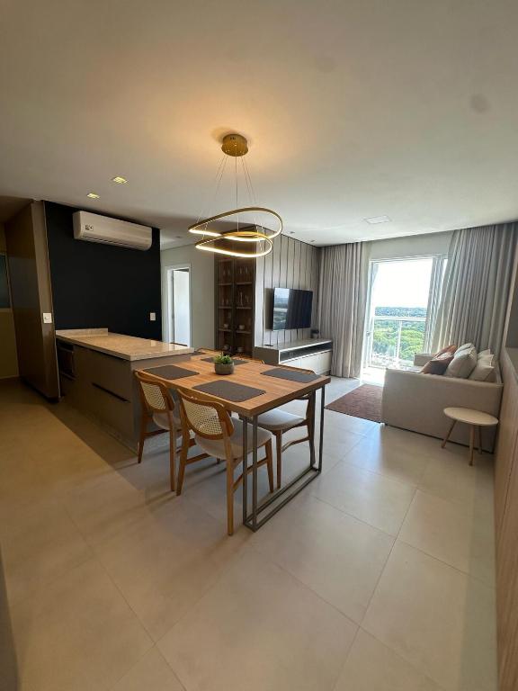 a kitchen and living room with a table and chairs at Apto Cancún Foz in Foz do Iguaçu