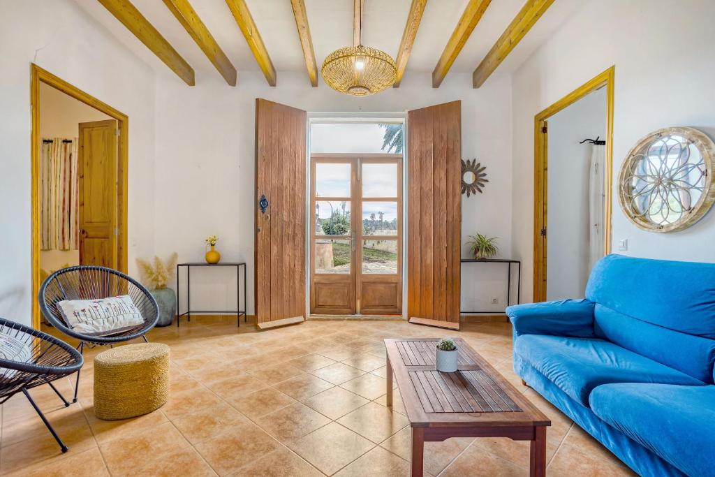 a living room with a blue couch and a table at Fora Vila in Manacor