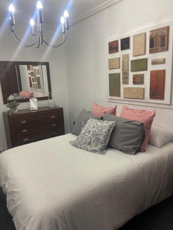 a bedroom with a large bed with a chandelier at Las Fadrique in Córdoba